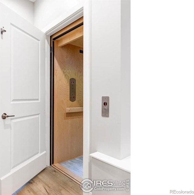 bathroom with hardwood / wood-style flooring and elevator