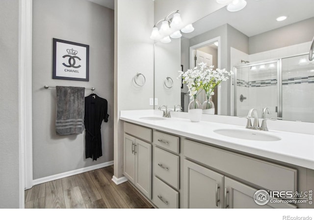 bathroom featuring an enclosed shower, vanity, and wood-type flooring