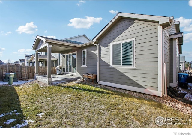 rear view of house with a yard and a patio