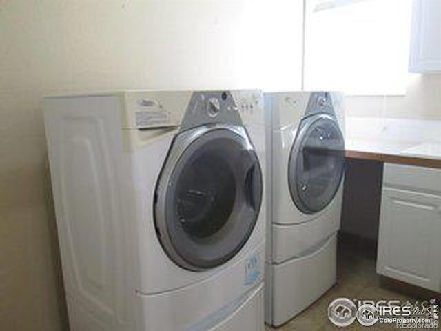 washroom featuring independent washer and dryer and cabinets