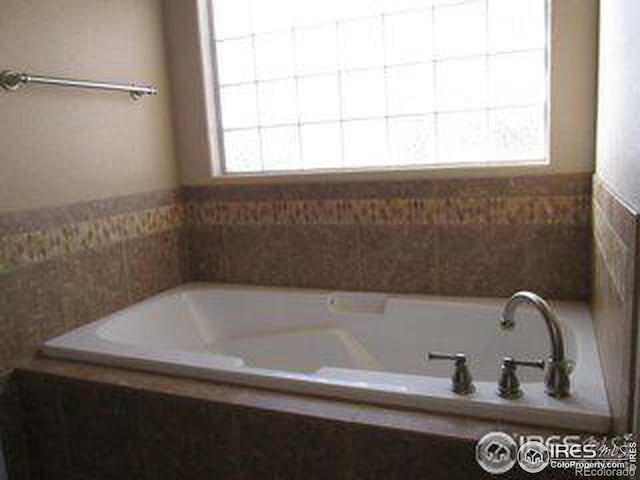 bathroom featuring tiled tub