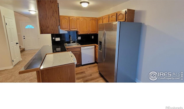 kitchen with white dishwasher, stainless steel fridge with ice dispenser, tasteful backsplash, and sink