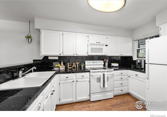 kitchen with white appliances, wood-type flooring, sink, white cabinetry, and backsplash