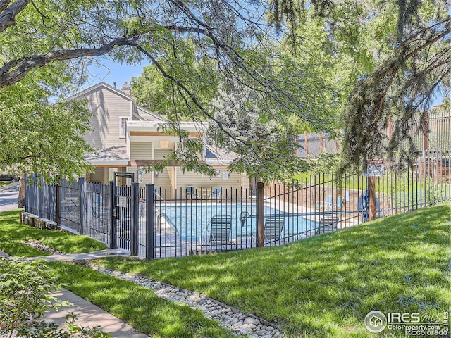 view of pool featuring a lawn