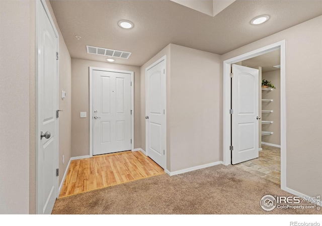 hallway featuring a textured ceiling and carpet