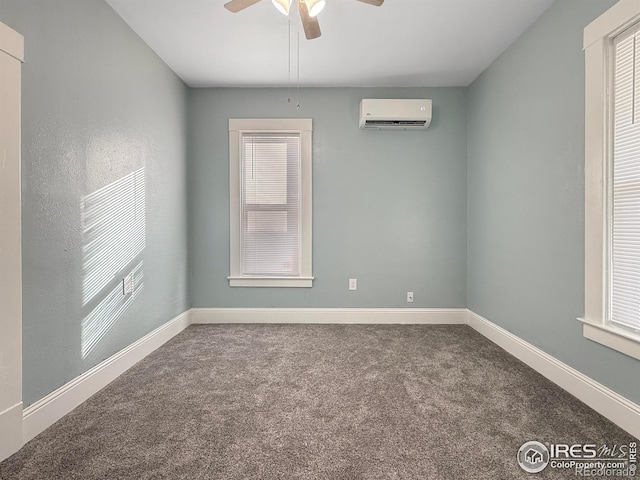 spare room with an AC wall unit, ceiling fan, and carpet flooring