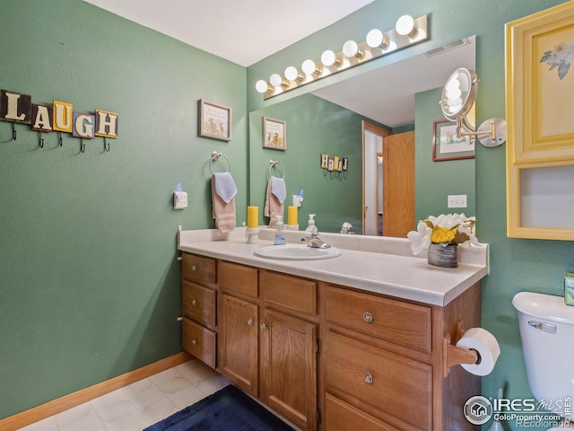 bathroom featuring toilet, tile patterned flooring, and vanity