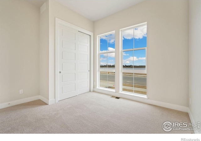 unfurnished bedroom featuring baseboards, visible vents, and carpet floors