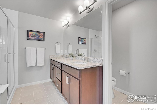 bathroom featuring toilet, tile patterned flooring, walk in shower, and vanity