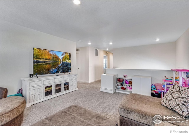 carpeted living room featuring a textured ceiling