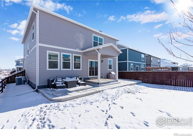 snow covered rear of property featuring central air condition unit