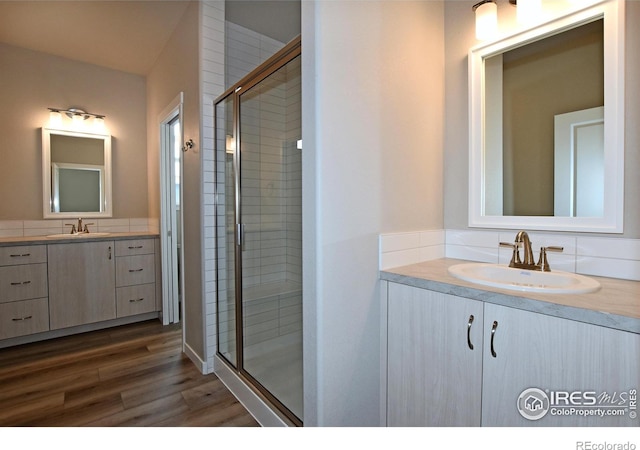 bathroom with wood-type flooring, walk in shower, and vanity