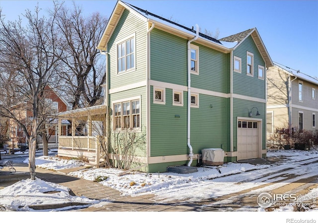 exterior space with covered porch and a garage