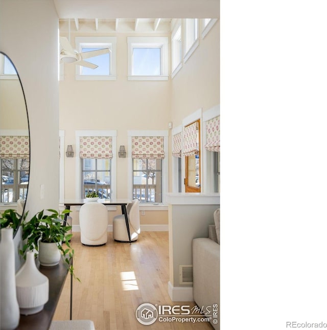 interior space featuring a towering ceiling and light hardwood / wood-style floors