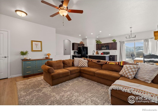 living room with ceiling fan and light hardwood / wood-style floors