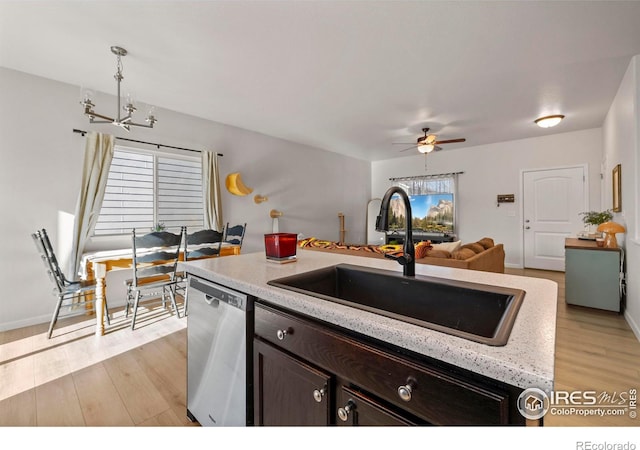 kitchen featuring sink, dishwasher, light hardwood / wood-style flooring, dark brown cabinets, and pendant lighting