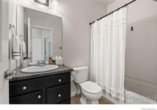 full bathroom featuring toilet, shower / bath combination with curtain, and vanity