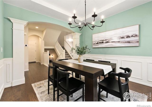 dining space featuring an inviting chandelier, a tray ceiling, and dark hardwood / wood-style floors