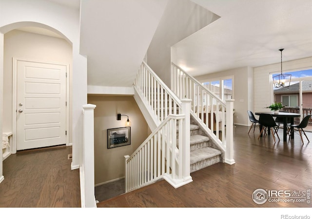 stairway with a chandelier and hardwood / wood-style floors