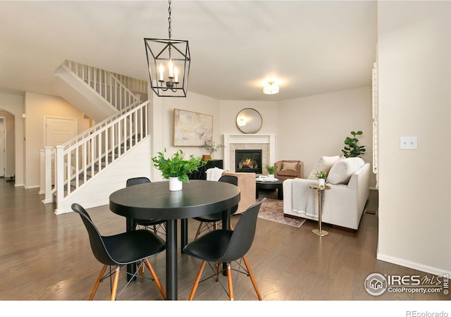 dining area with dark hardwood / wood-style flooring and an inviting chandelier