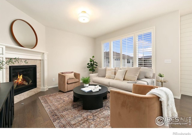 living room with dark wood-type flooring and a tiled fireplace