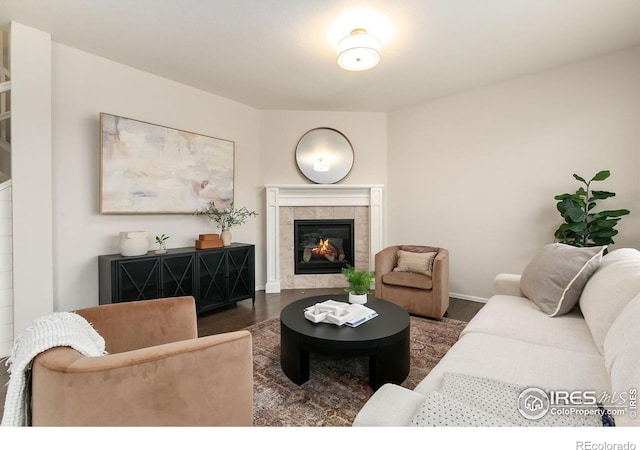 living room featuring dark hardwood / wood-style flooring and a tiled fireplace