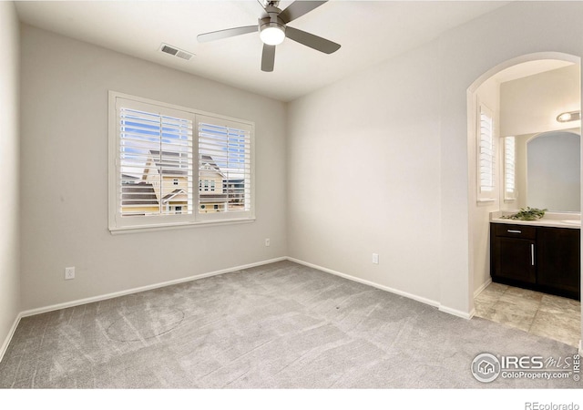 carpeted spare room featuring ceiling fan