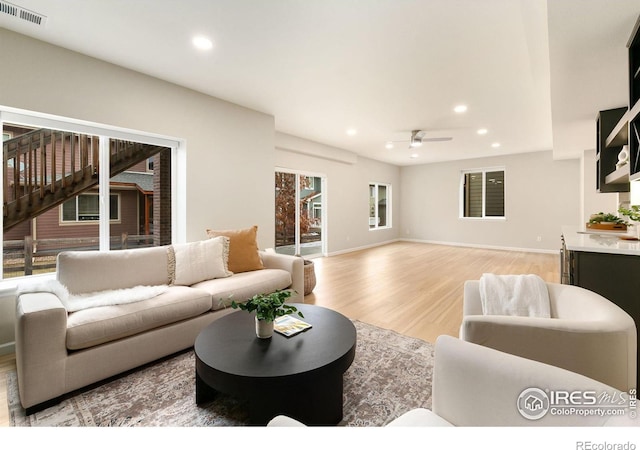 living room with ceiling fan and light hardwood / wood-style floors