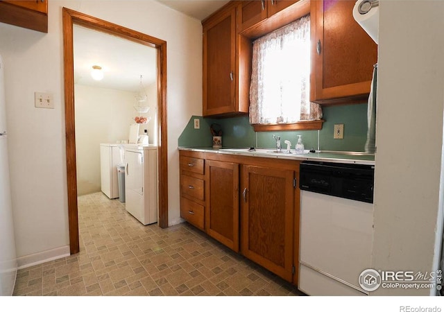 kitchen with white dishwasher, washing machine and dryer, and sink