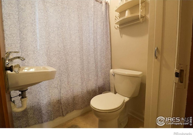 bathroom featuring toilet and a shower with curtain