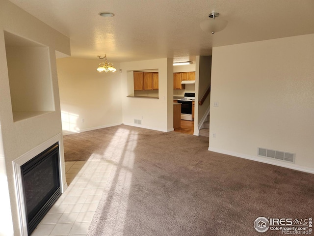 unfurnished living room featuring light colored carpet and an inviting chandelier