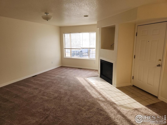 unfurnished living room with a textured ceiling and light colored carpet