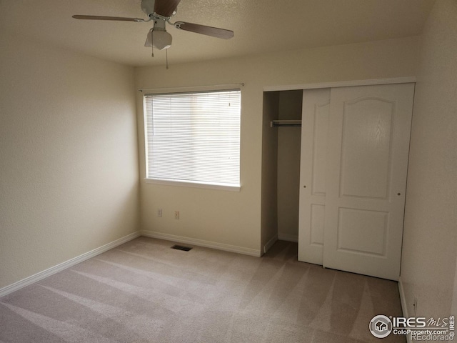 unfurnished bedroom featuring a closet, ceiling fan, and light carpet