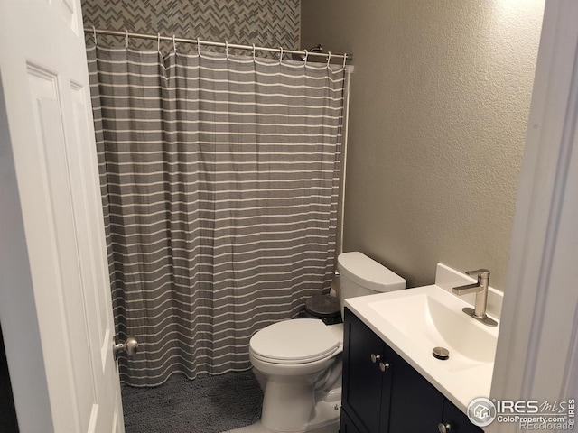 bathroom with toilet, a shower with shower curtain, and vanity