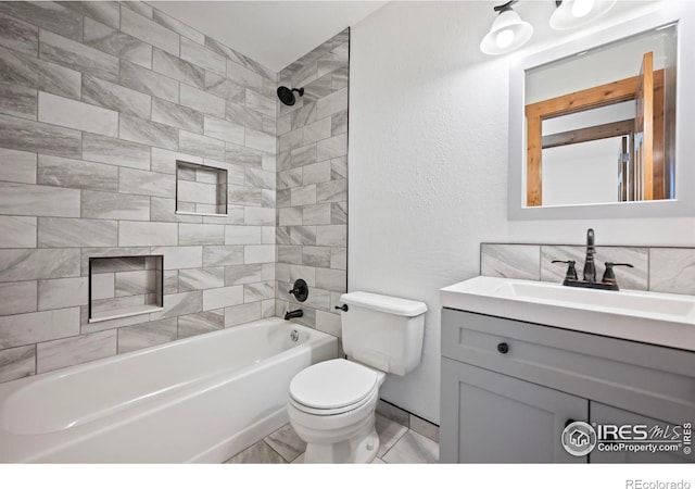 full bathroom featuring toilet, tiled shower / bath combo, and vanity