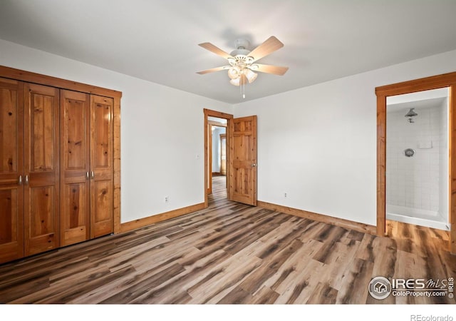 unfurnished bedroom featuring ceiling fan, a closet, and dark wood-type flooring