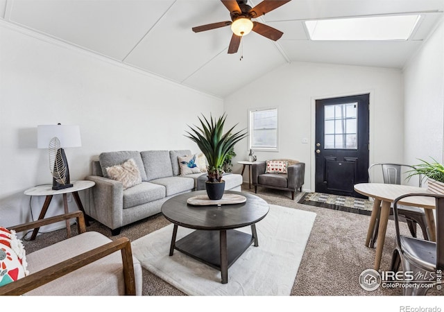 carpeted living room featuring ceiling fan and vaulted ceiling with skylight