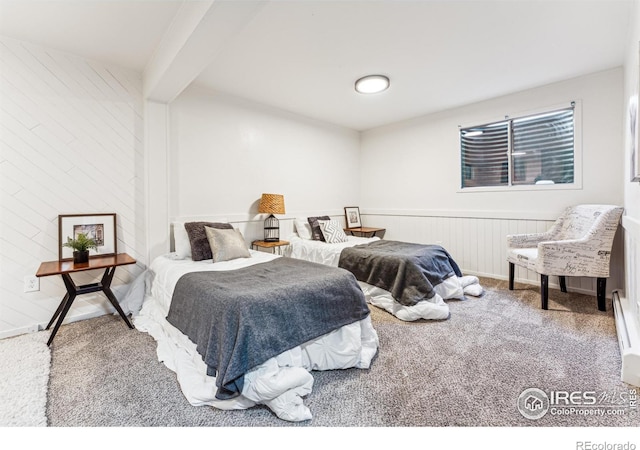 bedroom with wooden walls, carpet, and beamed ceiling