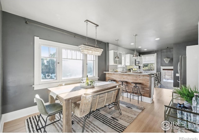 dining space featuring light hardwood / wood-style floors and a notable chandelier