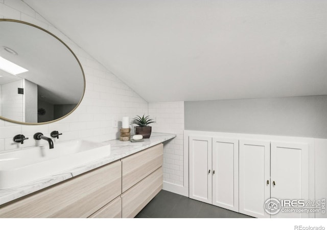 bathroom with vaulted ceiling and vanity