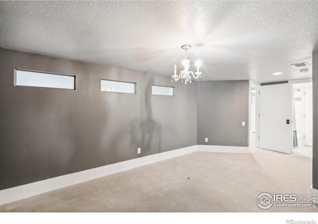 basement with a textured ceiling, light carpet, and a chandelier