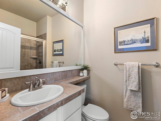 bathroom with toilet, an enclosed shower, vanity, and decorative backsplash