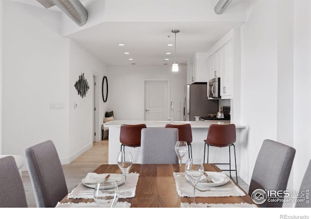 dining space with sink and light hardwood / wood-style flooring