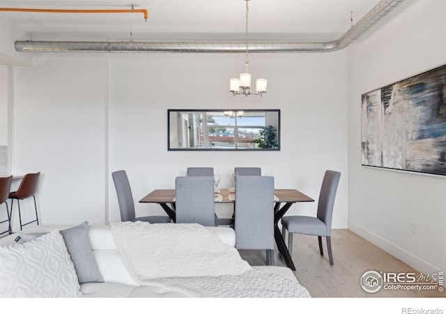 dining space featuring an inviting chandelier and light hardwood / wood-style floors