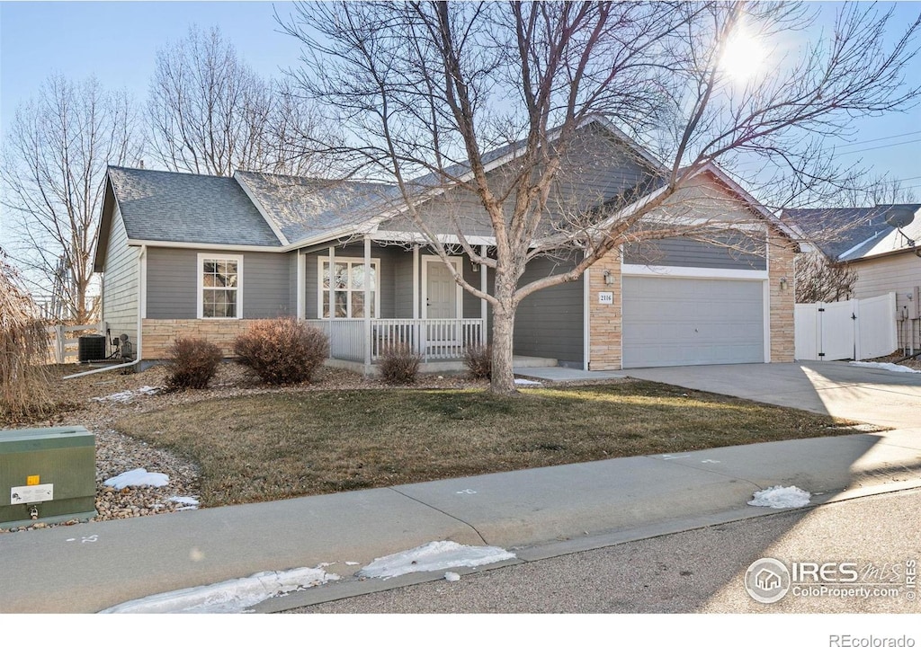 single story home with a front yard, central air condition unit, covered porch, and a garage