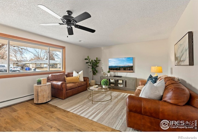 living room with a textured ceiling, ceiling fan, a baseboard radiator, and hardwood / wood-style flooring