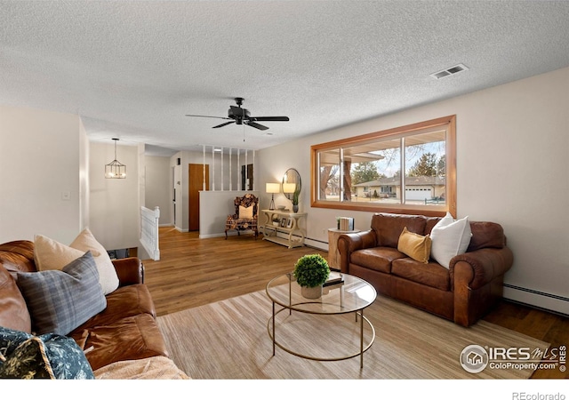 living room with light hardwood / wood-style floors, ceiling fan, a textured ceiling, and a baseboard heating unit