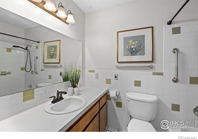 bathroom with a textured ceiling, tile walls, vanity, and toilet