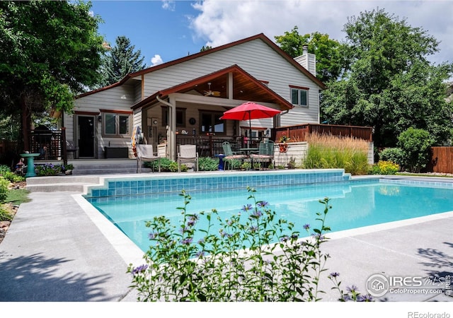 view of swimming pool featuring ceiling fan and a wooden deck