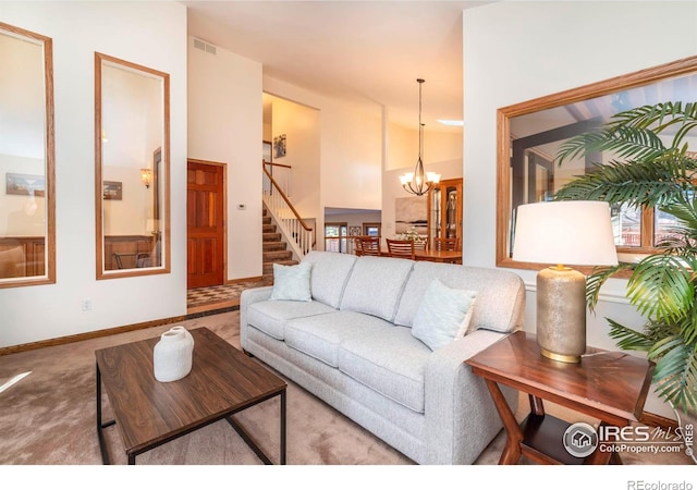 carpeted living room featuring an inviting chandelier